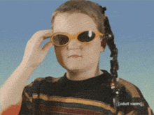 a girl wearing sunglasses and a sweater that says adult swim