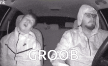two men are sitting in a car with the word groob on the bottom