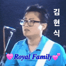 a man wearing glasses and a blue shirt is playing a guitar in front of a microphone and the words royal family are above him