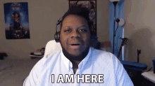 a man wearing headphones says " i am here " while looking at the camera