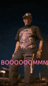 a man wearing a hat and a shirt that says ' booooommm ' on the bottom