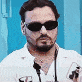 a man with a beard wearing sunglasses and a white shirt