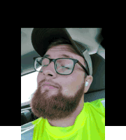 a man with glasses and a beard wears a yellow shirt