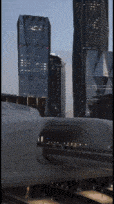 a train is going through a tunnel in front of a city skyline