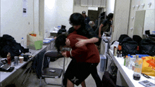 a man in a hurley shorts is hugging another man in a room