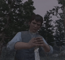 a man in a blue and white striped shirt is sitting in the woods