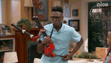 a man is playing a bagpipe in a living room with a nick logo in the background
