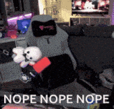 a stuffed animal is sitting in a gaming chair with the words nope nope nope below it