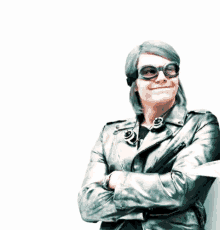 a man wearing a leather jacket and goggles is smiling .