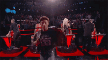 a man wearing a t-shirt that says ' warfare ' on it is standing on a stage