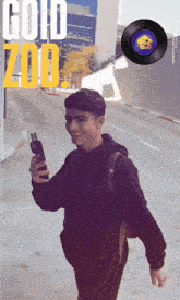 a young man is walking down a street with the words gold zoo written above him