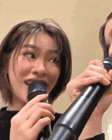 a woman singing into a microphone while looking at the camera