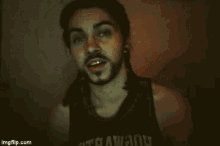 a man with a beard is smiling in a dark room with the words `` really '' above him .