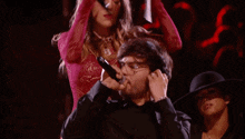 a woman in a red dress is dancing with a man in a black suit