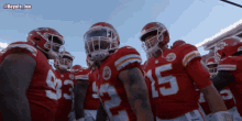 a group of football players are huddled together and one of them has the number 15 on their jersey