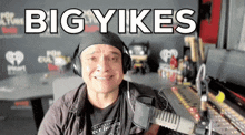 a man wearing headphones says " bigyikes " in a radio station
