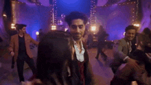 a group of people are dancing on a dance floor in a room .