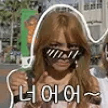 a woman wearing sunglasses and making a funny face is standing in front of a building .