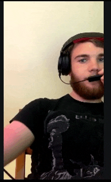 a man with a beard wearing headphones and a shirt that says elvis on it