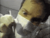 a man wearing a surgical mask and gloves is looking at the camera