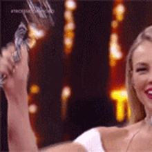 a woman is holding a trophy in her hand and smiling at the camera .