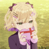a girl with blonde hair and green eyes is holding a heart shaped box