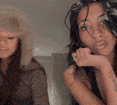 two women are standing next to each other and one has a fur hat on