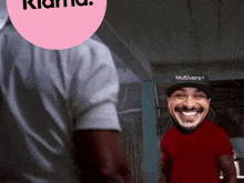 a man wearing a red shirt and a black hat with the word multivers on it