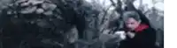 a blurry picture of a person in a red scarf standing in a forest .