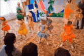 a group of little girls are dancing in a room with a dragon on the wall behind them
