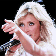 a close up of a woman singing into a microphone with the hashtag anahioverdose