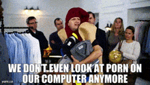 a man in a costume is holding a bunch of clothes and says we don t even look at porn on our computer anymore