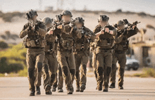 a group of soldiers are walking down a street with guns