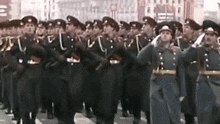a large group of soldiers marching down a street in a parade