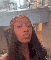 a woman wearing a headband and a nose ring is blowing a kiss .