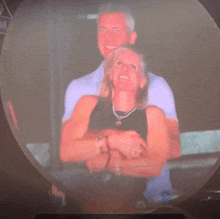 a man and a woman are hugging and smiling in a blurry photo