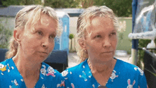 two women are wearing blue scrubs with rabbits on them and looking at each other .