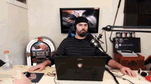 a man sitting at a desk with a msi laptop on it