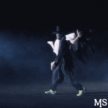 a man is carrying a woman in his arms and the letters ms are on the bottom right