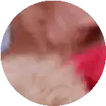 a close up of a person 's face in a circle with a red shirt on .