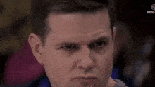 a man is making a funny face with his eyes closed .