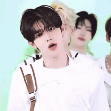 a close up of a person wearing a white shirt with a brown strap on the back