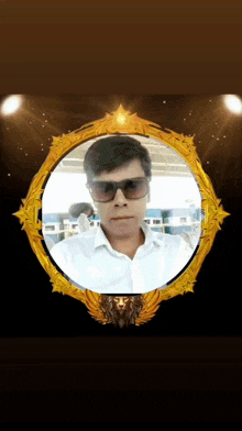 a man wearing sunglasses stands in a gold frame