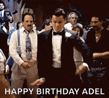 a man in a tuxedo is dancing in front of a crowd with the words happy birthday adel written below him