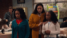 three girls are standing in front of a netflix ad