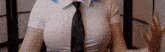 a woman wearing a white shirt and a black tie is sitting down .