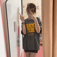 a girl taking a picture of herself in a mirror wearing a t-shirt that says best