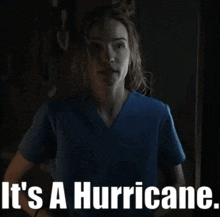 a woman in a blue scrub top with the words it 's a hurricane below her
