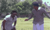 two men are standing in a field and one of them has the letter n on his chest