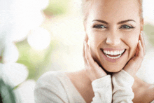 a woman with her hands on her face is smiling